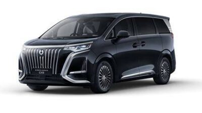 Dark blue luxury minivan seen from a front three-quarter angle, with a large chrome grille and sleek headlights.