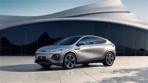 Silver crossover SUV parked on a light plaza in front of a curved glass building with a futuristic backdrop.