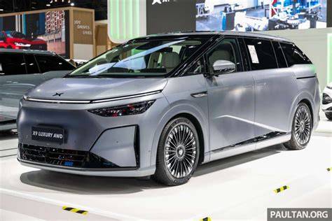 October 29, 2026 Silver multi-purpose vehicle on a showroom floor, front three-quarter view with large alloy wheels and slim LED headlights.